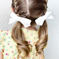 Girl Wearing 2 White Ribbed Skinny Bow Clips - Golden Dot Lane